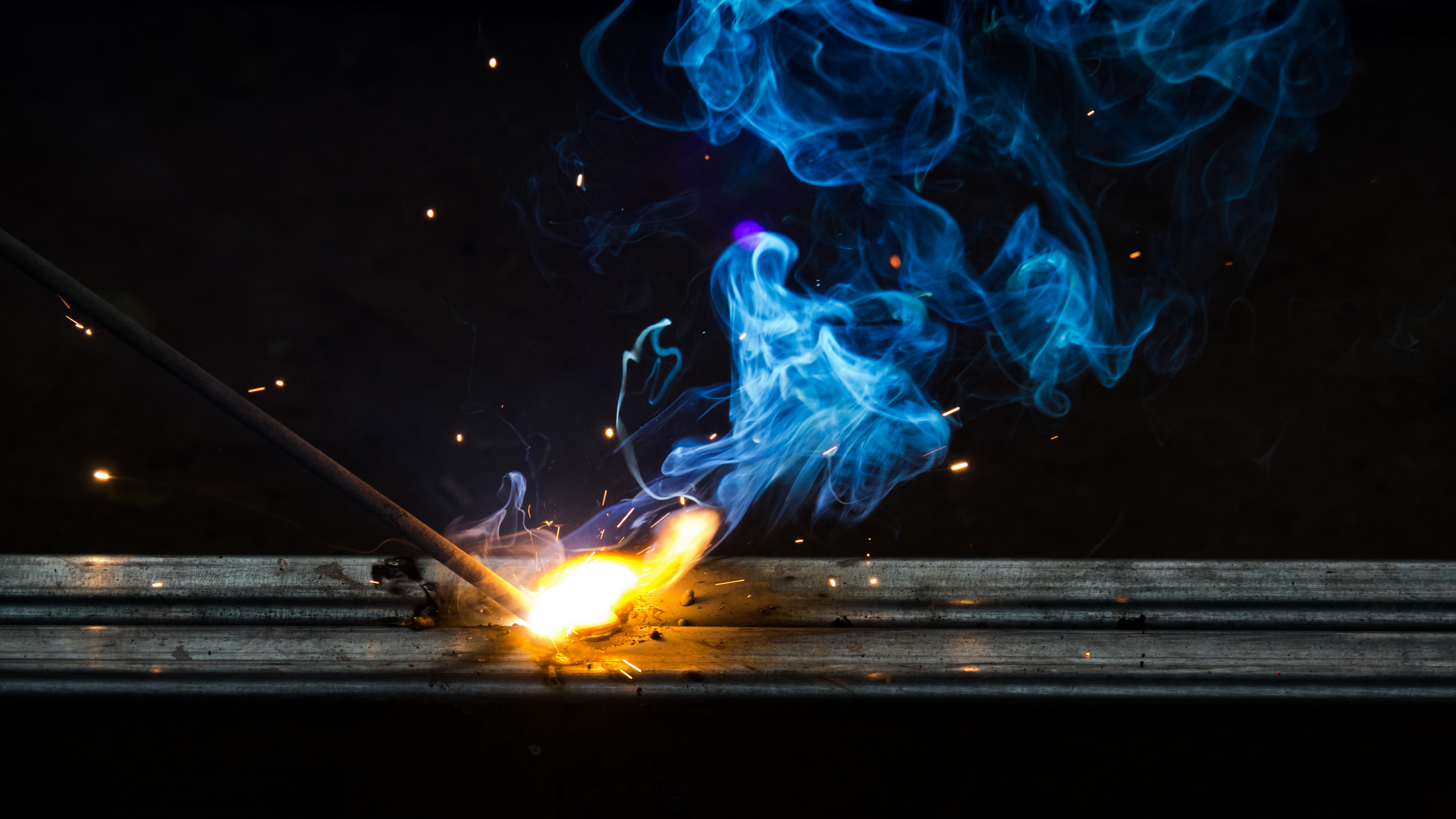 Smoke and flame of welding work on dark background